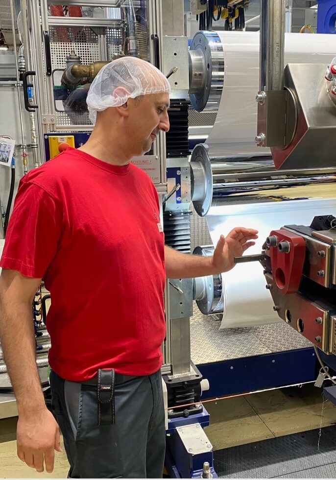 Der Betriebsmechaniker Mustafa Özer beim Anlagen überwachen in einem roten T-shirt
